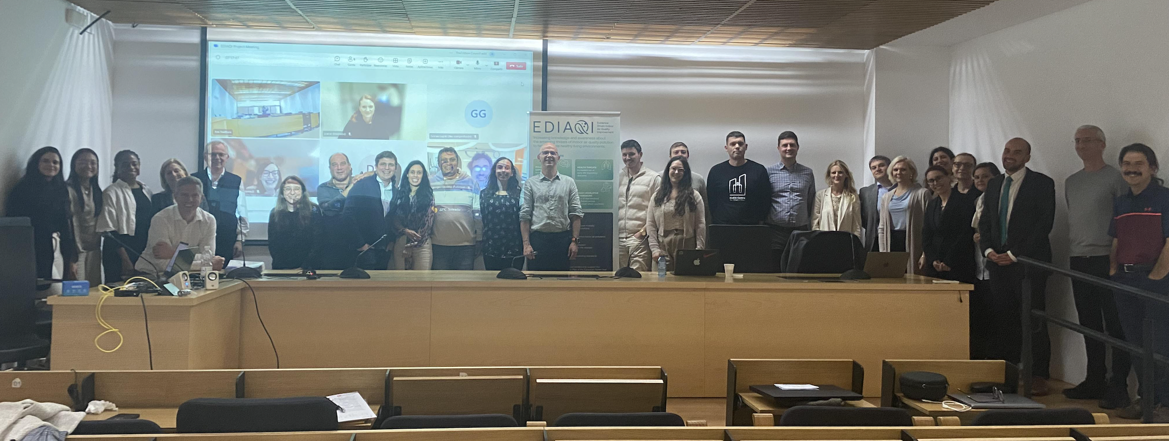 Photo of Consortium members present in Seville in Front of Project with online partners also visible.